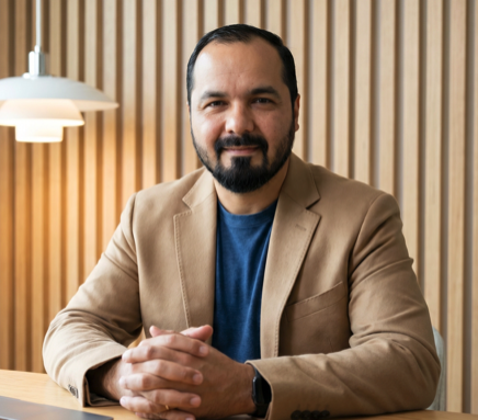 Salman Lakhani, seated at a table, looking at the camera
